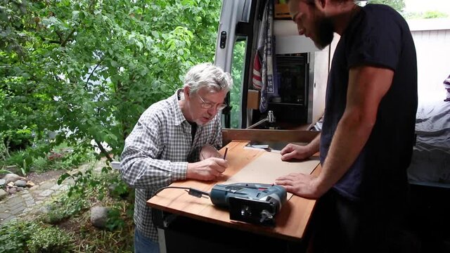 DIY camper van conversion, father and adult son working together