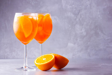 Aperol spritz cocktail on a gray background. Two glasses of aperol spritz with orange slised....