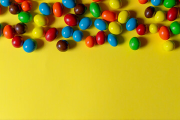 Multi-colored sweets on a yellow background. Copy space.