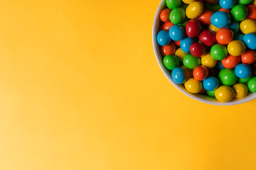 Multi-colored sweets on a yellow background. Copy space.