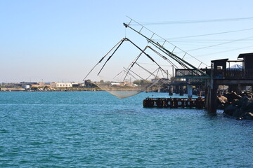 big fisher crane with nets in harbor at fiumicino italy