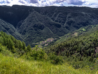 Fototapeta na wymiar Paesaggio con vallata di montagna e paesino visto dall'alto