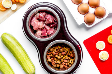 petfood set with vegetables and eggs on kitchen table background top view
