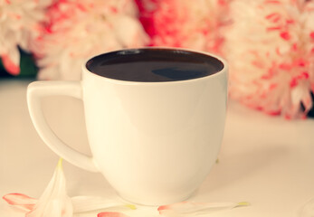 morning coffee in a white mug, flowers
