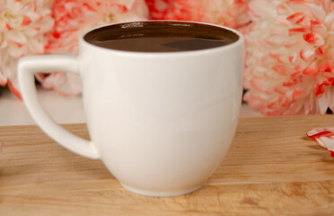 morning coffee in a white mug, flowers