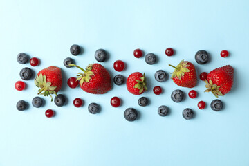 Flat lay with fresh berries on blue background, top view