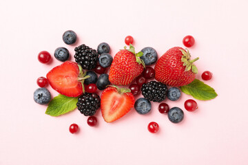 Mix of fresh berries on pink background, top view