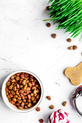 dry dog food in bowl on stone background top view