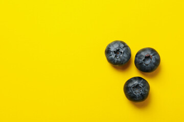 Delicious fresh blueberry on yellow background, top view