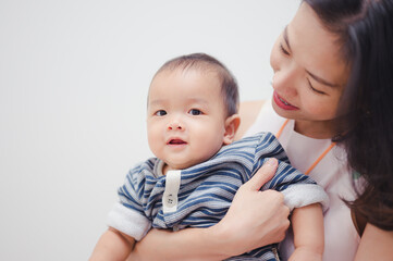 Happy Asian 8 months baby boy with his mother ,Happy family concept