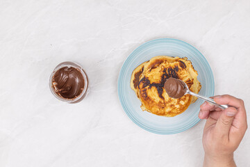 Top view of pancakes with chocolate cream on the plate