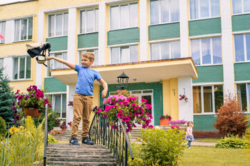 Fototapeta na wymiar Portrait of a schoolchild with backpack leaping . the boy runs a backpack around the school yard.Childhood, education learning concept