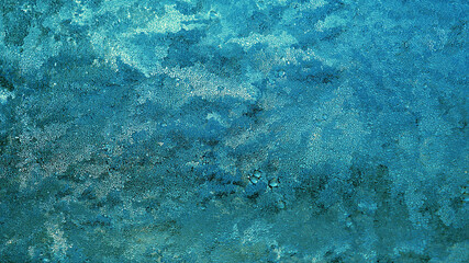 Abstract turquoise, aquamarine and blue background. Chaotic spots and stains, similar to seething seawater. Wallpaper with bright saturated color. Tinted frost on glass in winter