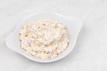 Russian Salad served in the bowl above grey marble table