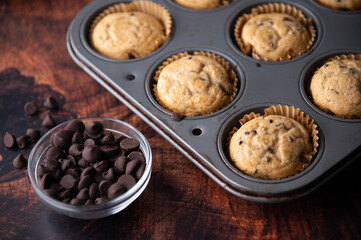 chocolate chip muffin on dark wooden board