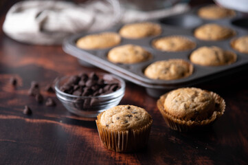 chocolate chip muffin on dark wooden board