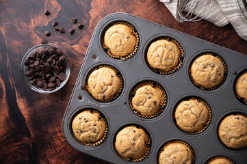 chocolate chip muffin on dark wooden board