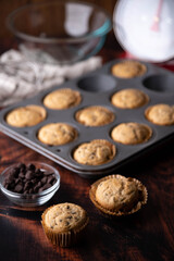chocolate chip muffin on dark wooden board