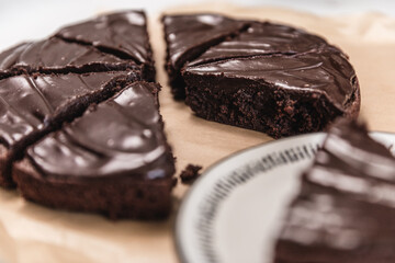  Eight slices of chocolate brownie cake on top of parchment paper on a white table.  - 364550949