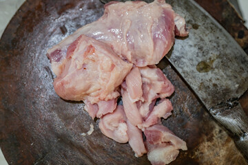 Lump of lard on the wooden board with chopping knive on the right.