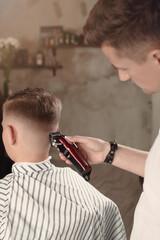 Men's hairstyling and hair cutting in a barber shop or hair salon.