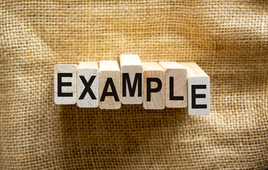 Concept word 'example' on wooden blocks on a beautiful canvas background. Business concept.