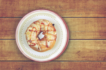 Delicious glazed doughnuts on wooden table