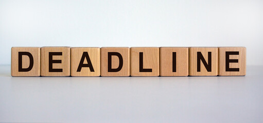 Concept word 'deadline' on wooden cubes on a beautiful wooden table. White background. Business...