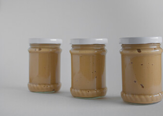 three jars of peanut butter on white background 