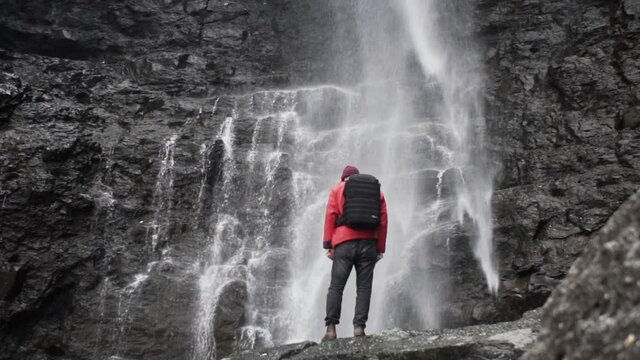 Hiker Standing Underneath Fossa Waterfall