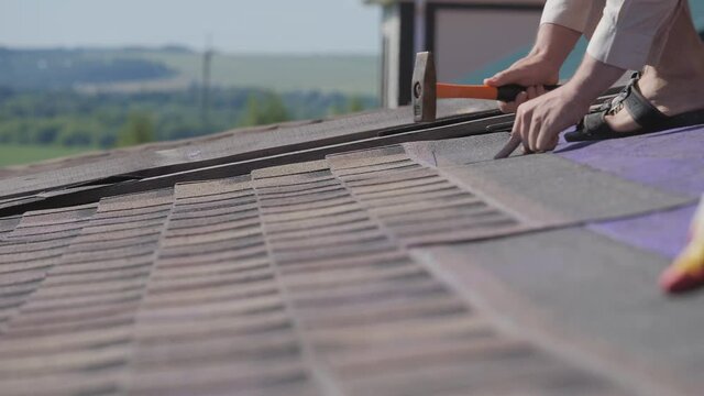 Roofing work. Laying a soft roof on the roof of a private house.