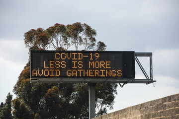 Los Angeles, California / USA - April 4, 2020: Freeway signs telling the public to stay home and avoid gathering during the coronavirus outbreak and pandemic  - 364554992