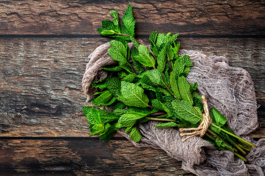 Top view of bunch of fresh green aromatic mint twigs arranged on rustic wooden table