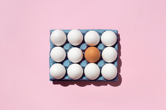Top view of seamless background of brown and white eggs placed on pink surface in studio