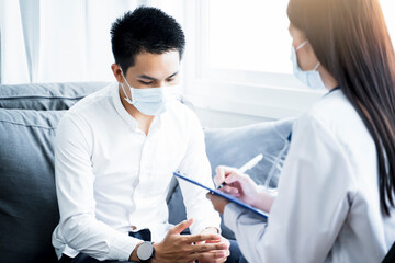 Asian Medical healthcare clinic doctor examining diagnosing male worry depressed anxious patient clipboard writing wearing surgical mask protection infection disease, working at home modern office