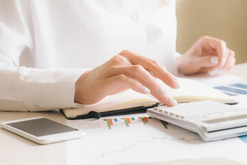 Close up businesswoman hand using calculator about finance accounting.finance accounting concept