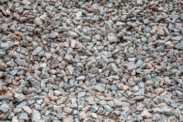 Gray textured surface of a heap of construction pebbles and gravel