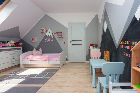 Children bedroom for a boy and a girl with painted mountains on the walls