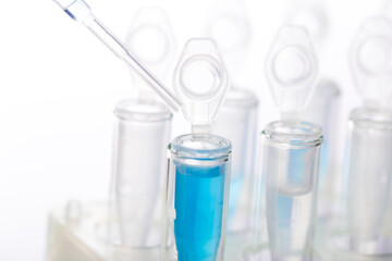 microbiological pipette in the genetic laboratory. study of a virus or vaccination. blue tinted.