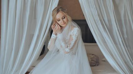The bride straightens earrings before the morning before the wedding.