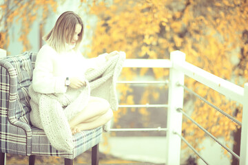 beautiful woman in a sexy look, autumn look with a book, reads in a park