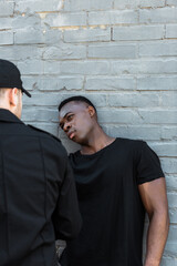 Obraz premium Selective focus of worried African American man looking at policeman, racism concept