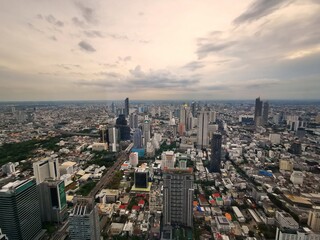 Top view aerial from the tallest skyscraper building of the metropolitan  Bangkok, Thailand with modern architectural building and beautiful river  in the evening sunset time. 