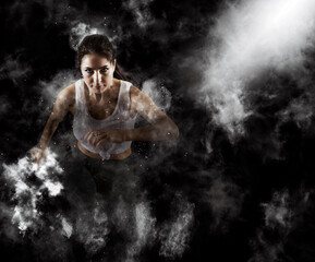 Fototapeta na wymiar Sporty young woman running on smoke background