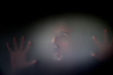 Unidentifiable male with mustache gray beard wide eyed open mouth screaming face hands pressed...
