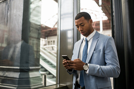Trendy black businessman using phone