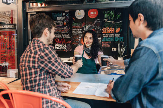 Bartender handing drink to customers