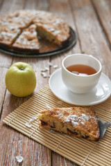 Pile of small homemade pancakes with honey, tea cup and honeycomb on wooden table