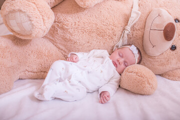 Healthy child, sweetest blonde toddler girl sleeping in bed holding her teddy bear. Adorable toddler girl holding her teddy bear. My Best Friend and family and baby protection concept.