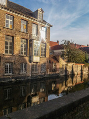 Fototapeta na wymiar Canal and old buildings in the medieval city of Bruges in northern Belgium. This city is known as Venice of the North by its canals in the center of the city.